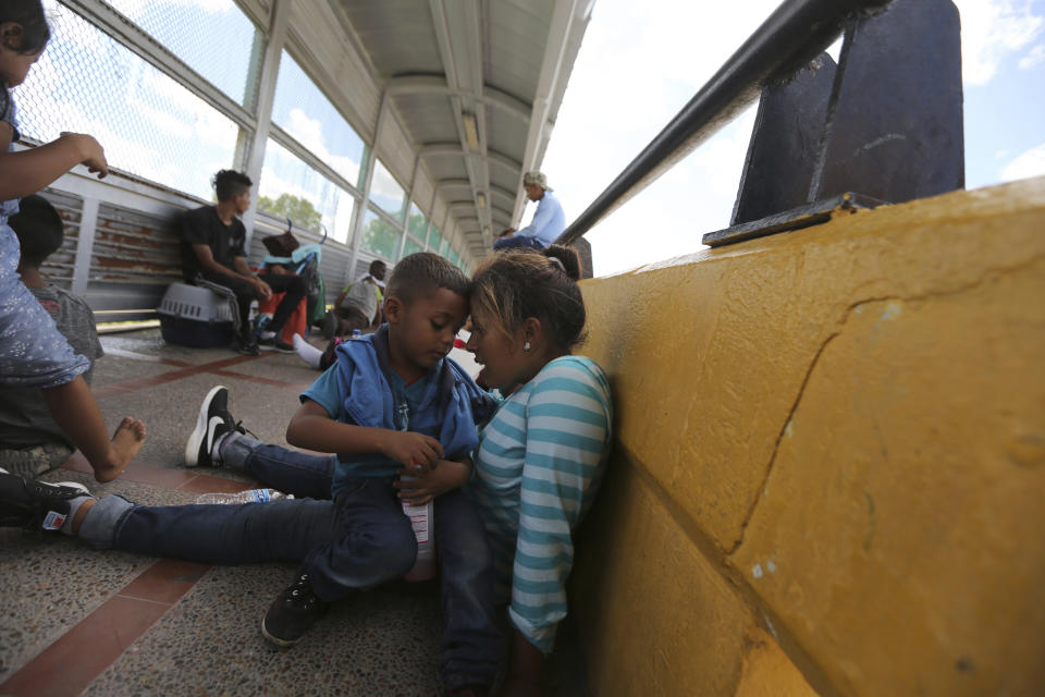 A migrant mother and child share a moment after camping out on the Gateway International Bridge that connects downtown Matamoros, Mexico with Brownsville, Thursday, Oct. 10, 2019. Migrants wanting to request asylum camped out on the international bridge leading from Mexico into Brownsville, Texas, causing a closure of the span. (AP Photo/Fernando Llano)