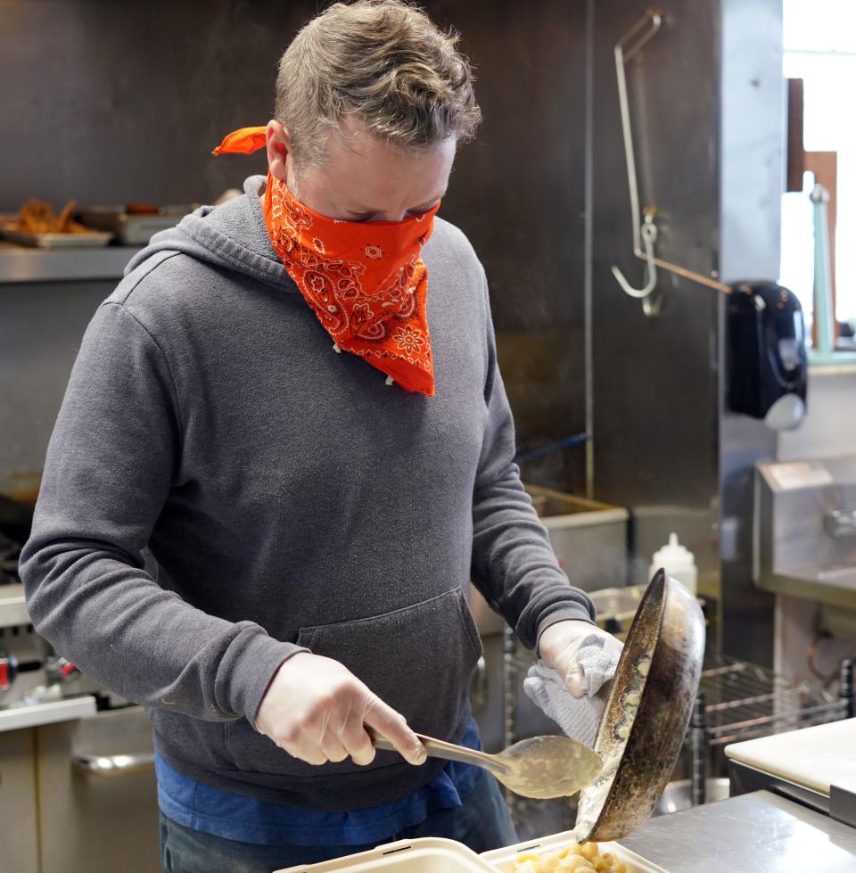 Kevin Grossi, the owner of the Fort Collins, Colorado-based restaurant The Regional, finishes cooking a to-go order during the coronavirus outbreak. Grossi is struggling to keep his 18-month-old restaurant running during the widespread closure orders, and has pivoted to selling comfort food like fried chicken and mac-and-cheese to his customers.