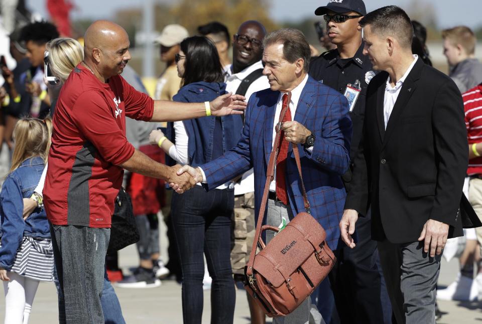 University of Alabama head coach Nick Saban, center, greets a supporter after arriving with the team at Tampa International Airport Friday, Jan. 6, 2017, in Tampa, Fla. Alabama takes on Clemson Monday in the College Football Playoff championship game. (AP Photo/Chris O'Meara)