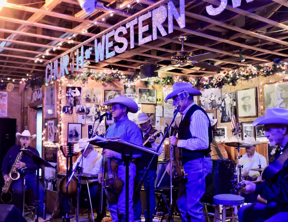 Fiddler Greg Gibbs of Iowa Park sings Friday night at the Church of Western Swing in Turkey, Texas. 
The town celebrated its 51st Bob Wills Day on Saturday, ending several days of musical events with a parade, car show, outdoor concert presented by Bob Wills’ Texas Playboys under the direction of Jason Roberts and a dance at the Bob Wills Center featuring Jody Nix and The Texas Cowboys. 
The yearly event attracts large numbers of Western Swing musicians and fans. 
The Church is a popular venue for nightly music and also for church on Sunday morning. 
Other musicians, from left, are Alfie Johns, Bob Baker, Buster Redwine, Jimmy Burson, John Jones (partially visible), Robby Crow and Tommy Thomsen.