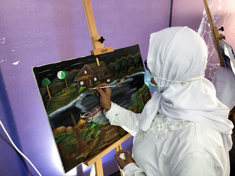 A female inmate paints at a correctional and rehabilitation centre during a government-guided tour for the media in Badr City