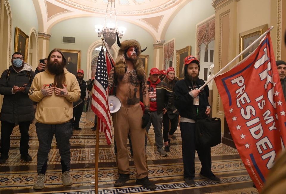 Supporters of US President Donald Trump, including member of the QAnon conspiracy group Jake Angeli, aka Yellowstone Wolf (C), enter the US Capitol on January 6, 2021, in Washington, DC. - Demonstrators breeched security and entered the Capitol as Congress debated the a 2020 presidential election Electoral Vote Certification.
