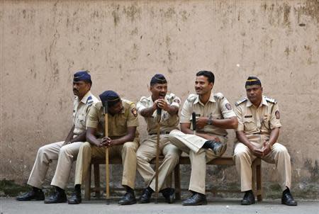 A policeman (C) yawns as he sits with his colleagues outside a court where the case of the gang rape of a photojournalist was heard in Mumbai March 20, 2014. REUTERS/Mansi Thapliyal