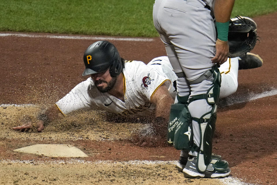 CORRECTS TO RELIEF PITCHER NOT STARTING PITCHER - Pittsburgh Pirates' Austin Hedges scores on a sacrifice fly by Jack Suwinski off Oakland Athletics relief pitcher Shintaro Fujinami during the sixth inning of a baseball game in Pittsburgh, Monday, June 5, 2023. (AP Photo/Gene J. Puskar)