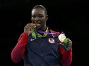 2016 Rio Olympics - Boxing - Victory Ceremony - Women's Middle (75kg) Victory Ceremony - Riocentro - Pavilion 6 - Rio de Janeiro, Brazil - 21/08/2016. Gold medallist Claressa Shields (USA) of USA bites her medal from Rio 2016 while posing with her other medal from London 2012. REUTERS/Peter Cziborra