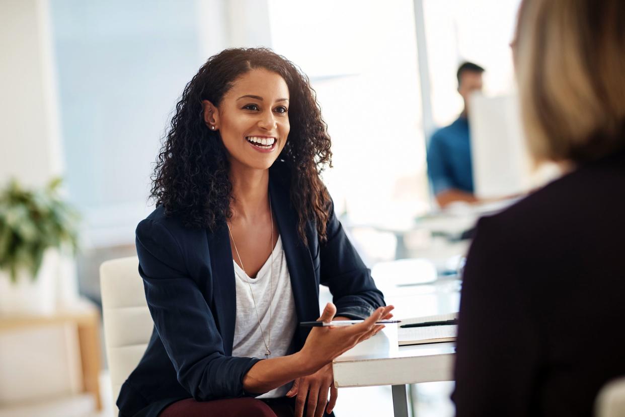 happy mixed-race woman talking with employee