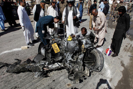 Security officials inspect a wreckage of a vehicle after a blast in Quetta, Pakistan October 18, 2017. REUTERS/Naseer Ahmed