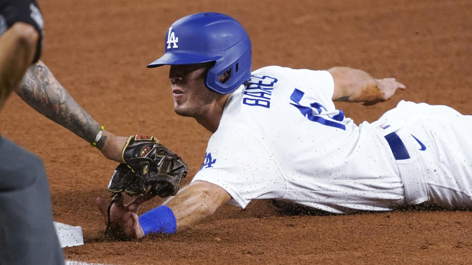 Los Angeles Dodgers' Austin Barnes (15) is tagged out by San Diego Padres third baseman Manny Machado while trying to advance on a hit by Mookie Betts during the fourth inning in Game 2 of a baseball National League Division Series Wednesday, Oct. 7, 2020, in Arlington, Texas. (AP Photo/Tony Gutierrez)