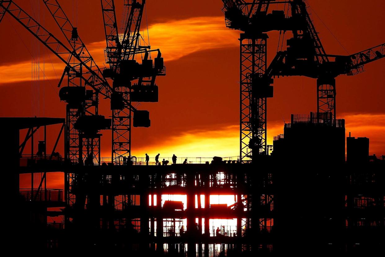 Workers are seen as the sun sets behind a construction site in London, Britain, January 21, 2020: REUTERS