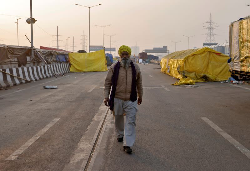 A farmer walks at a site where farmers have gathered to protest against farm laws at Ghaziabad