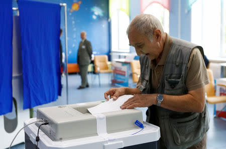 FILE PHOTO: A man casts his ballot during mayor election at a polling station in Moscow, Russia September 9, 2018. REUTERS/Sergei Karpukhin