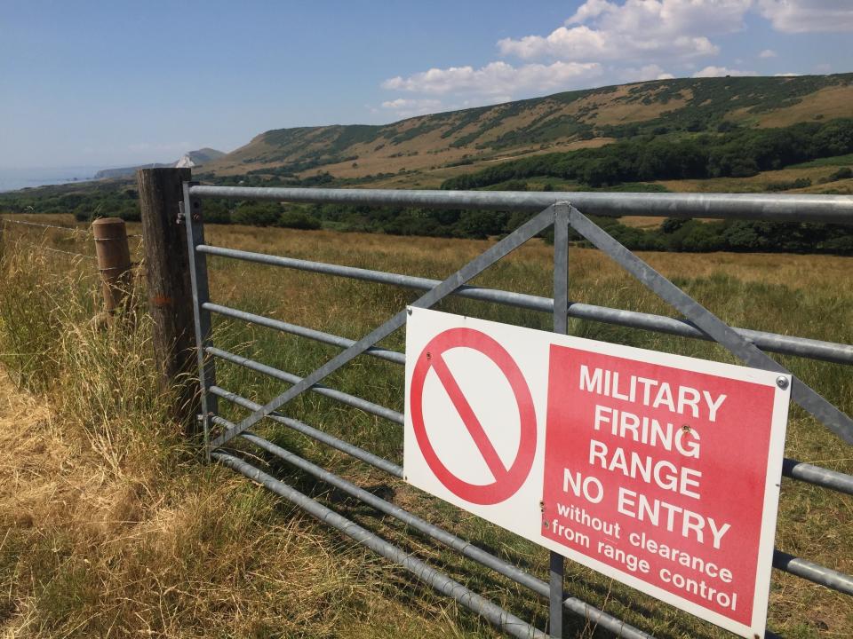 Un cartel anuncia la existencia de un campo de tiro cerca de Tyneham, Inglaterra, un caserío que tuvo que ser abandonado por sus residentes en plena Segunda Guerra Mundial para que las fuerzas armadas lo usasen en maniobras militares y capacitación de soldados. Foto del 8 de julio del 2018. (AP Foto/Jerry Harmer)