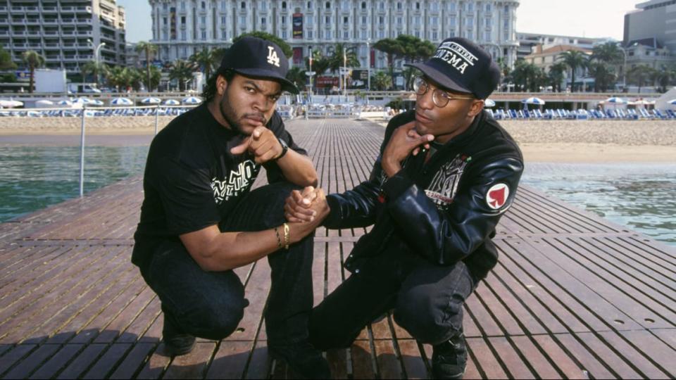 (L-R) Ice Cube and “Boyz n the Hood” director <span class="caas-xray-inline-tooltip"><span class="caas-xray-inline caas-xray-entity caas-xray-pill rapid-nonanchor-lt" data-entity-id="John_Singleton" data-ylk="cid:John_Singleton;pos:2;elmt:wiki;sec:pill-inline-entity;elm:pill-inline-text;itc:1;cat:Director;" tabindex="0" aria-haspopup="dialog"><a href="https://search.yahoo.com/search?p=John%20Singleton" data-i13n="cid:John_Singleton;pos:2;elmt:wiki;sec:pill-inline-entity;elm:pill-inline-text;itc:1;cat:Director;" tabindex="-1" data-ylk="slk:John Singleton;cid:John_Singleton;pos:2;elmt:wiki;sec:pill-inline-entity;elm:pill-inline-text;itc:1;cat:Director;" class="link ">John Singleton</a></span></span>. (Photo by Pool ARNAL/GARCIA/PICOT/Gamma-Rapho via Getty Images)