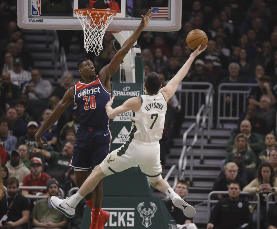 Washington Wizards' Ian Mahinmi, left, defends against Milwaukee Bucks' Ersan Ilyasova during the first half of an NBA basketball game Tuesday, Jan. 28. 2020, in Milwaukee. (AP Photo/Jeffrey Phelps)