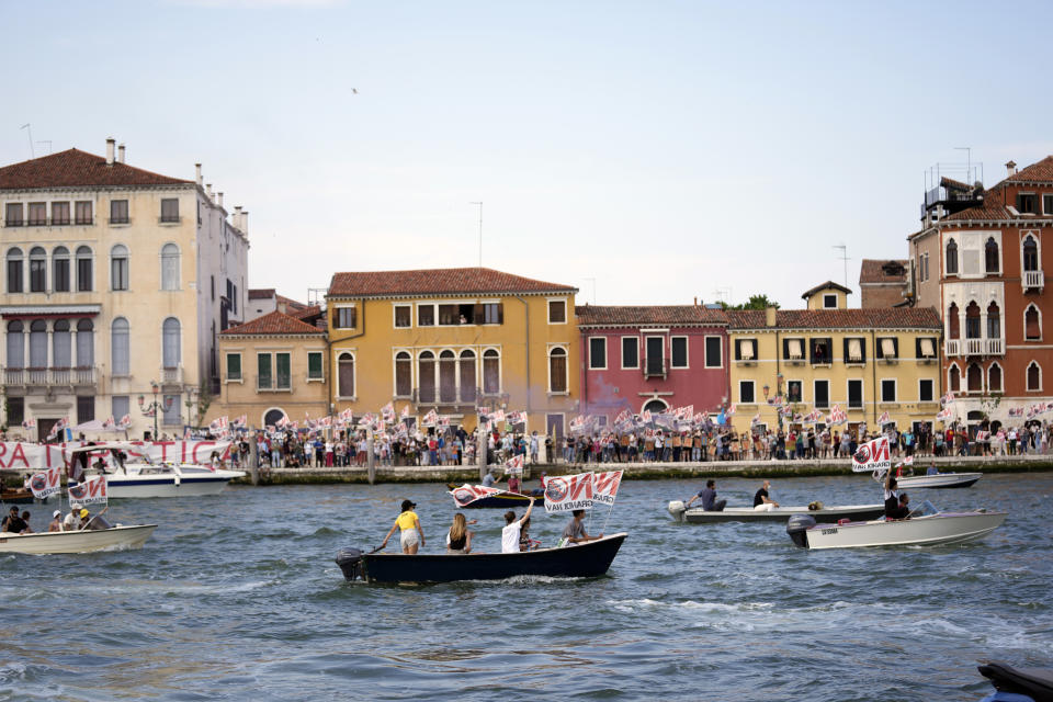 "No Big Ships" activists stage a protest as the MSC Orchestra cruise ship leaves Venice, Italy, Saturday, June 5, 2021. The 92,409-ton, 16-deck MSC Orchestra cruise ship, the first cruise ship leaving Venice since the pandemic is set to depart Saturday amid protests by activists demanding that the enormous ships be permanently rerouted out the fragile lagoon, especially Giudecca Canal through the city's historic center, due to environmental and safety risks. The ship passed two groups of protesters: pro-cruise advocates whose jobs depend on the industry as well as protesters who have been campaigning for years to get cruise ships out of the lagoon. (AP Photo/Antonio Calanni)