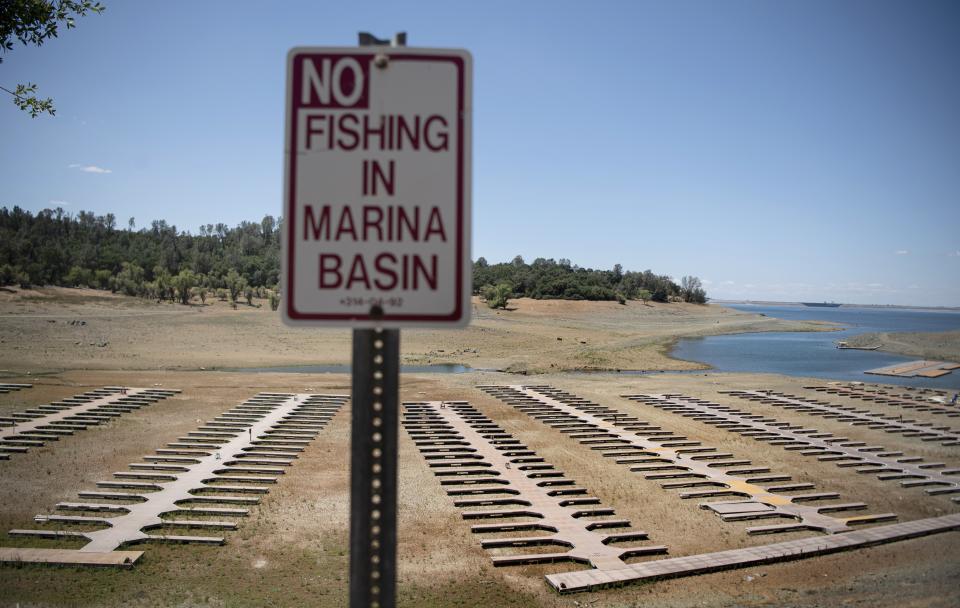 FILE - Empty boat dock sit on dry land at the Browns Ravine Cove area of drought-stricken Folsom Lake in Folsom, Calif., on May 22, 2021. Months of winter storms have replenished California's key reservoirs after three years of punishing drought. (AP Photo/Josh Edelson, File)