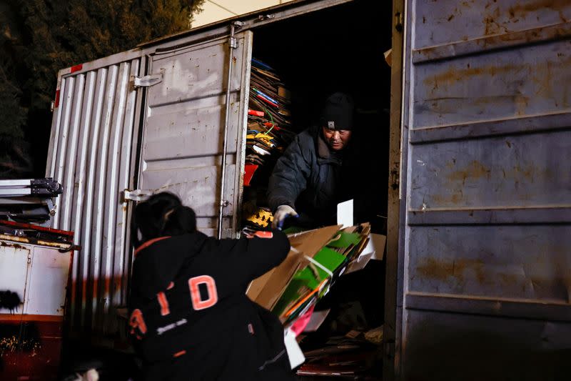 Wu loads cardboards onto a truck at a recycling station in Beijing