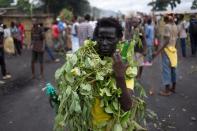 A protester dressed in leaves and holding bottles filled with stones stands at the edge of a demonstration in the Musaga neighbourhood of Bujumbura on May 6, 2015