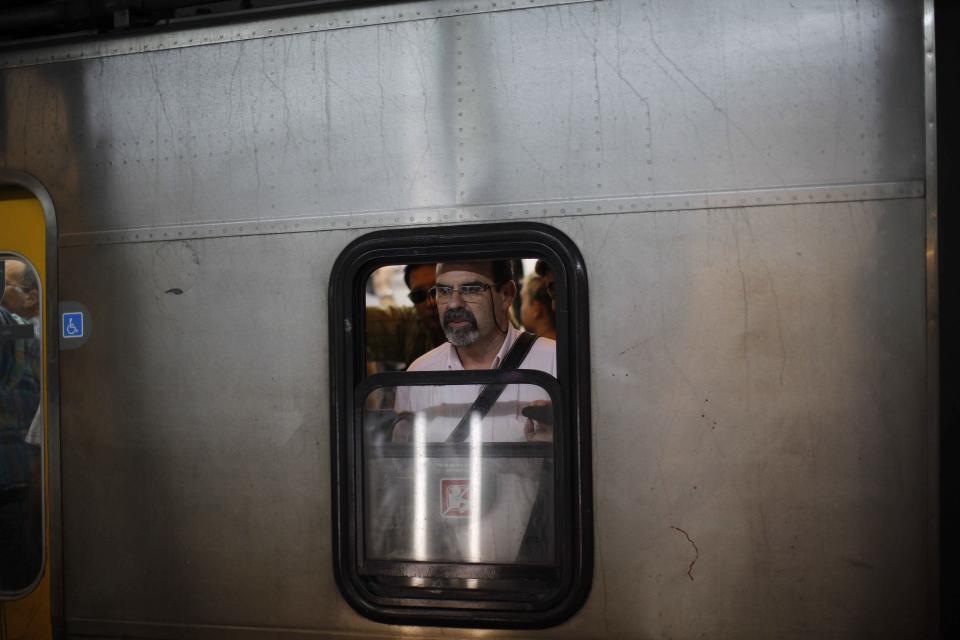 In this Feb. 11, 2014 photo, a commuter looks out a subway car window in Buenos Aires, Argentina. Argentines have suffered through a tough summer, with tropical rain that provided no relief from the heat and humidity, people having to throw out rotten food because of rolling power blackouts and soaring oil and gas prices, all amid rising inflation that is making it ever harder to reach the end of the month. The strain is evident on the faces of subway riders and others making their way home in Buenos Aires, where signs of poverty and decay are ubiquitous just beyond the glamorous streets where tourists go. (AP Photo/Rodrigo Abd)