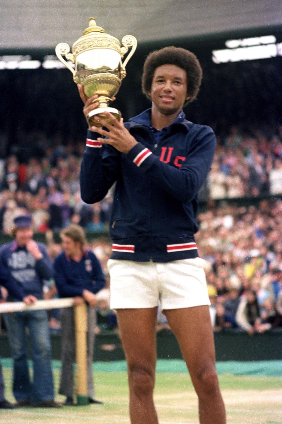 Arthur Ashe holds his Wimbledon trophy after defeating Jimmy Connors in the men's singles final in 1975.