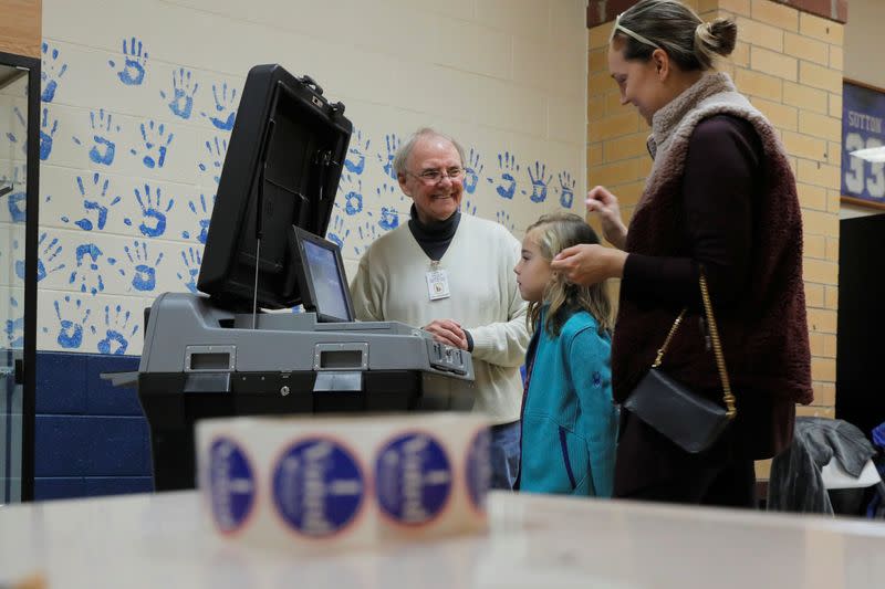 A woman finishes casting her ballot with her daughter at a polling station for the South Carolina primary in Indian Land South Carolina