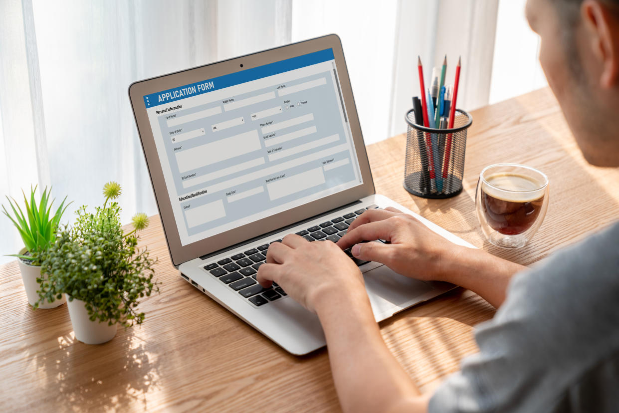 a man sat at a computer filing in an Online application form for a job