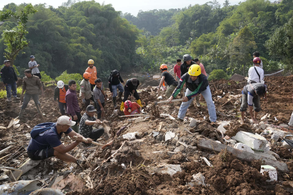 Rescuers dig through the mud as they search for victims of an earthquake-triggered landslide in Cianjur, West Java, Indonesia, Wednesday, Nov. 23, 2022. Indonesian rescuers used jackhammers, circular saws and sometimes their bare hands to shift the rubble of flattened buildings as they searched for the dead and missing from an earthquake that killed hundreds of people. (AP Photo/Tatan Syuflana)