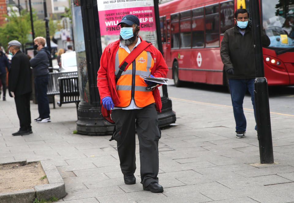 A postman wearing protective personal equipment walks through East Ham, east London, as the UK continues in lockdown to help curb the spread of the coronavirus. Picture date: Tuesday April 28, 2020. 