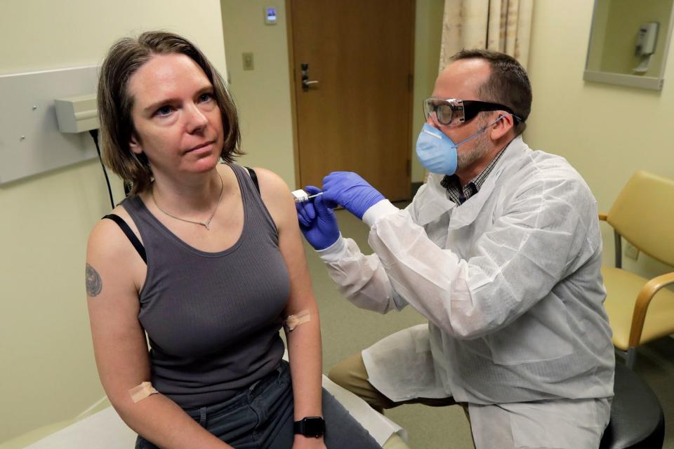 A pharmacist gives a volunteer the first shot in the first-stage safety study clinical trial of a potential Covid-19 vaccine developed by Moderna. 