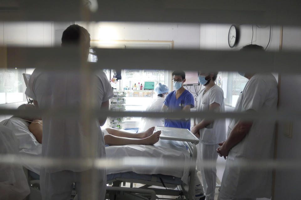 Medical staff meets in a room of a patient affected by COVID-19 virus in the ICU unit at the Ambroise Pare clinic in Neuilly-sur-Seine, near Paris, Friday, March 19, 2021. French Prime Minister Jean Castex announced new coronavirus restrictions as the number of COVID-19 patients in intensive care units spikes. (AP Photo/Thibault Camus)