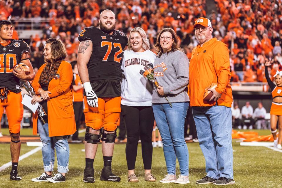 Oklahoma State left guard Josh Sills (72) stands beside his sister, Nicole Johnson, his mom, Kim, and his dad, John, during senior night festivities before the Cowboys' 37-33 win over OU on Nov. 27.