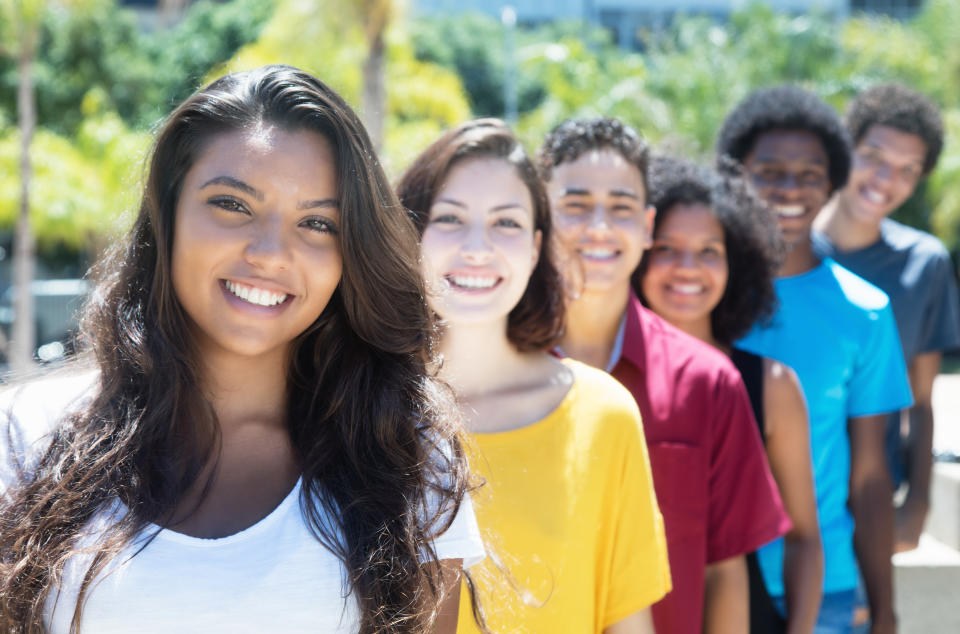 Latin and caucasian and african american and hispanic young adults in a row outdoor in the summer