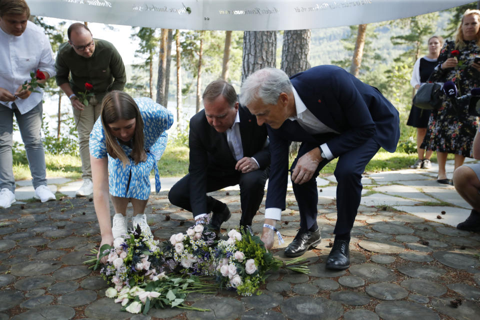 Leader of AUF youth political league in Norway, Astrid Hoem, Prime Minister of Sweden Stefan Lofven and leader of the Norwegian Labor Party Jonas Gahr Store, lay flower tributes at the memorial on Utoya island Wednesday July 21, 2021, the day before the 10th anniversary of the terrorist attack. The memorial to the attack victims, remains a construction site beset by changing plans, delays and court interventions, on the 10th anniversary of the July 22 attack that left 77 people dead on Utoya in Norway. (Beate Oma Dahle / NTB via AP)