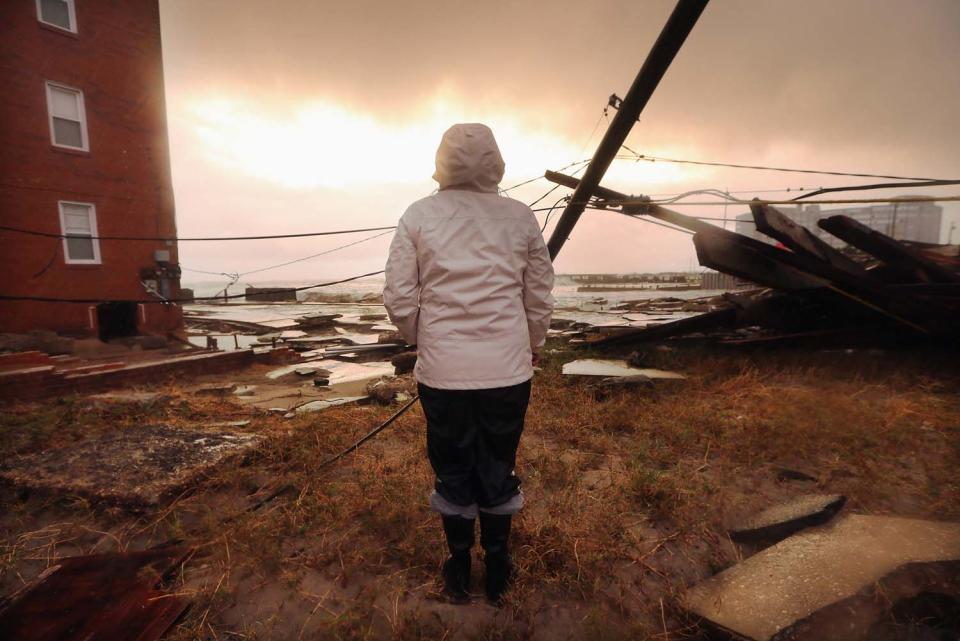La residente Kim Johnson inspecciona el área que rodea el edificio donde vive y que se inundó tras el paso del huracán Sandy por el malecón de Atlantic City, New Jersey, el 30 de octubre de 2012. Mario Tama/Getty Images