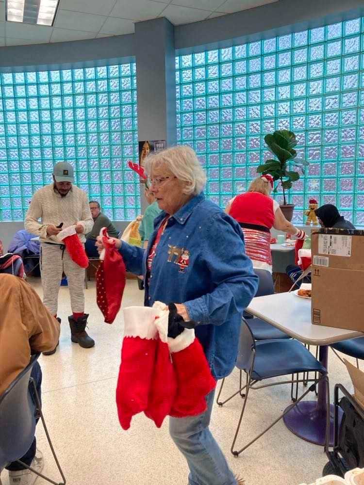 Robin Ann Carter hands out Christmas stockings during a Christmas party put on by Warm for the Winter also known as the Wagon Train Warriors. The group feeds homeless people every week.