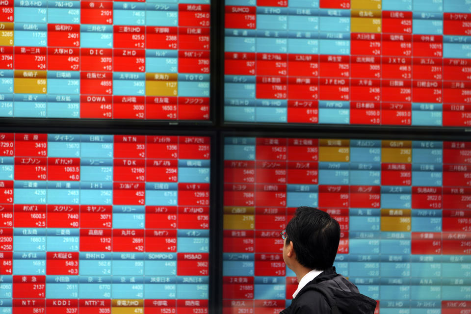 A man looks at an electronic stock board showing Japan's Nikkei 225 index at a securities firm in Tokyo Wednesday, Dec. 11, 2019. (AP Photo/Eugene Hoshiko)