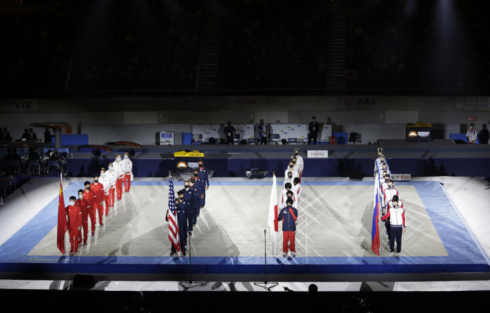 Gymnasts from four countries China, from left, U.S., Japan and Russia line up for the opening ceremony of an international gymnastics meet in Tokyo on Sunday, Nov. 8, 2020. The postponed Tokyo Olympics are to open in just under nine months. The International Olympic Committee and Japanese organizers have unwavering support from Japan’s ruling party and Tokyo’s municipal government. But there is a tiny murmur of resistance to the Olympic behemoth. A few voices in the national legislature question the wisdom of holding the Olympics in a pandemic. (AP Photo/Hiro Komae)