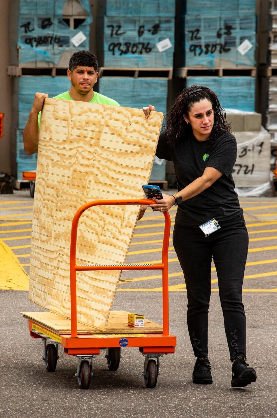 Leslie Rodriguez , right and her husband Raphael Berrios left load carry out construction materials at Home Depot in preparation for Hurricane Ian In Lakeland Fl. Tuesday September27,2022. Rodriguez said they have plenty of experience getting prepared as they had lived through hurricanes in Puerto Rico.Ernst Peters/.The Ledger