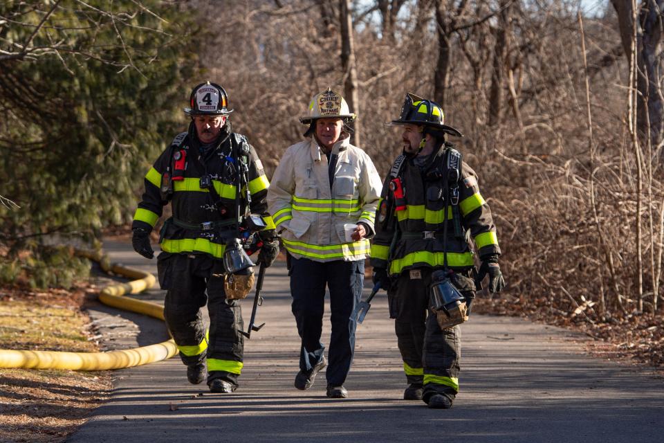 Maynard Fire Chief Angela Lawless, center, walks down the driveway with Concord firefighters after fighting a fatal fire at 30 Goodman’s Hill Road in Sudbury early Wednesday, Feb. 21, 2024.