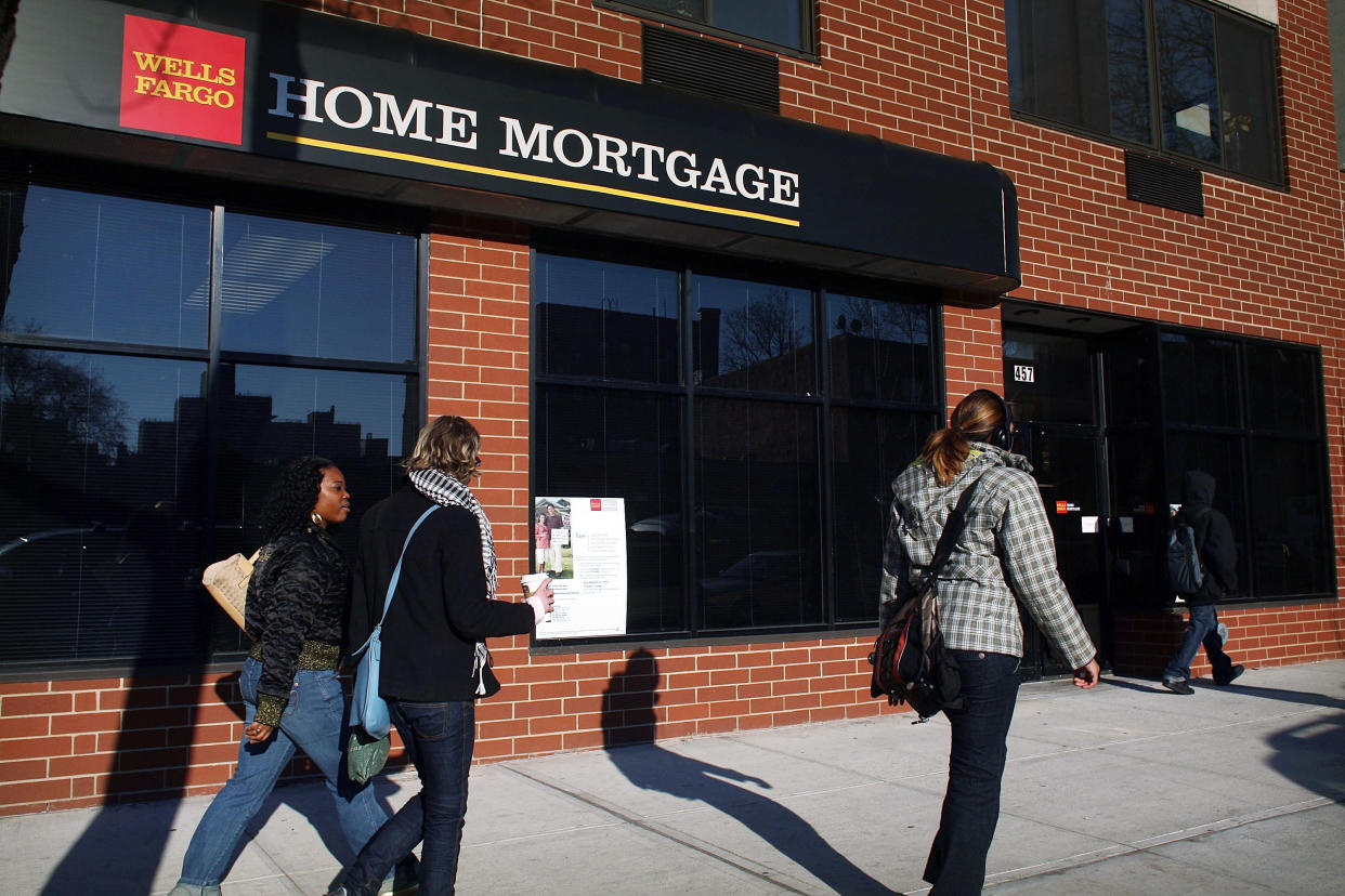 People walk by a Wells Fargo Home Mortgage branch in the Brooklyn borough of New York City. (Credit: Spencer Platt/Getty Images)