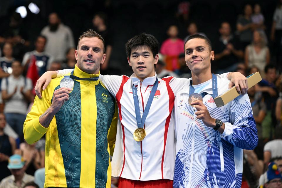 Kyle Chalmers, Pan Zhanle and David Popovici celebrate with their medals.