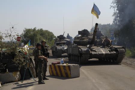 Ukrainian army tanks move past a checkpoint as they patrol the area near eastern Ukrainian town of Debaltseve August 3, 2014. REUTERS/Valentyn Ogirenko