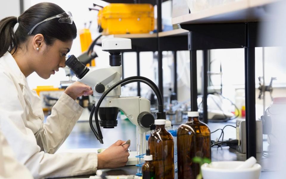 Scientist using microscope in laboratory