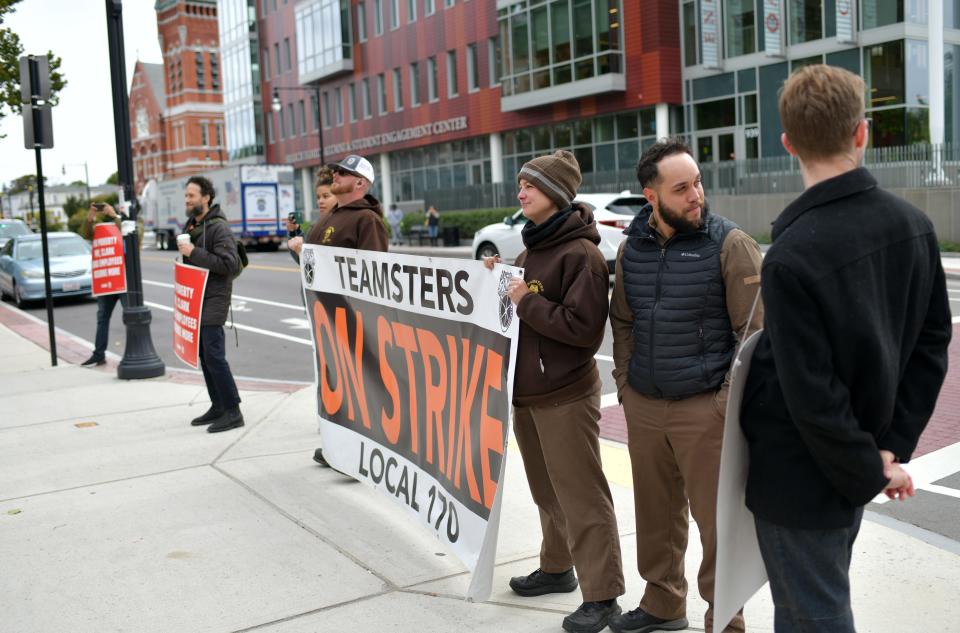 UPS workers from Teamsters Local 170 hold a banner in support of the Clark University  graduate student workers who went on strike Monday in Worcester.