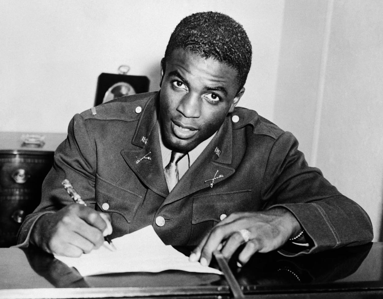Wearing his military uniform, Jackie Robinson signs a contract on Oct. 23, 1945 to becomes the first Black to play with a white professional baseball team. <a href="https://www.gettyimages.com/detail/news-photo/jackie-robinson-in-military-uniform-becomes-the-first-news-photo/514867314?adppopup=true" rel="nofollow noopener" target="_blank" data-ylk="slk:Bettmann/Getty Images;elm:context_link;itc:0;sec:content-canvas" class="link ">Bettmann/Getty Images</a>