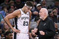 San Antonio Spurs head coach Gregg Popovich, right, speaks with Spurs center Zach Collins during the first half of a preseason NBA basketball game against the Houston Rockets, Wednesday, Oct. 18, 2023, in San Antonio. (AP Photo/Darren Abate)