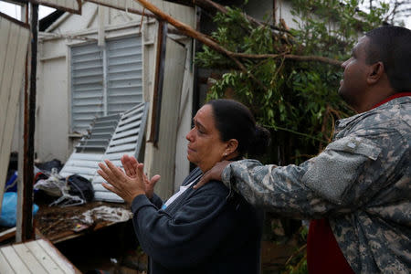 A woman reacts while she looks at the damages in the house of her mother after the area was hit by Hurricane Maria in Guayama, Puerto Rico September 20, 2017. REUTERS/Carlos Garcia Rawlins