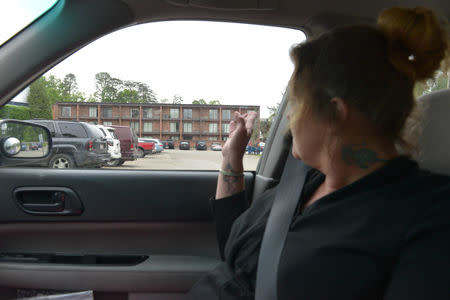 Debra Bright points to the Prestera live-in rehabilitation facility where she spent 10 days seeking sobriety in Huntington, West Virginia, May 4, 2017. REUTERS/Lexi Browning