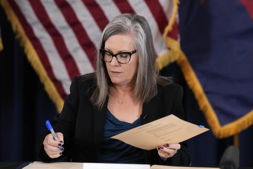 Katie Hobbs, the Democratic governor-elect and current secretary of state, signs the official certification for the Arizona general election canvass during a ceremony at the Arizona Capitol in Phoenix, Monday, Dec. 5, 2022. (AP Photo/Ross D. Franklin, Pool)