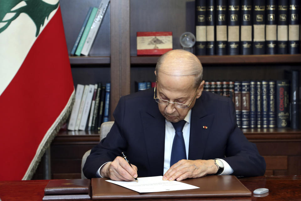 In this photo released by Lebanon's official government photographer Dalati Nohra, Lebanese President Michel Aoun signs the U.S.-brokered deal setting a maritime border between Lebanon and Israel, at the presidential palace, in Beirut, Lebanon, Thursday, Oct. 27, 2022. Lebanon signed and delivered its copy of a U.S.-mediated sea border deal with Israel on Thursday to a U.S. mediator, hoping to soon start exploring gas in its southern maritime blocs to bring economic stability to the crisis-ridden country. (Dalati Nohra/Lebanese Government via AP)